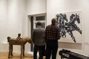 Deux hommes observent une peinture en noir et blanc