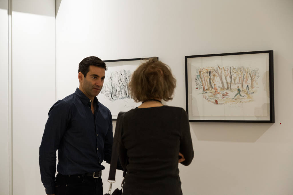 Un homme et une femme discutent devant deux oeuvres d'art